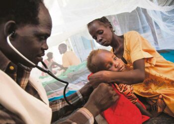Eteläsudanilainen lääkäri tutki tuberkuloosia sairastavaa lasta YK:n rauhanturvaajien valvomassa siviilien suojeluleirissä, joka sijaitsee taistelujen tuhoamassa Malakalin kaupungissa.