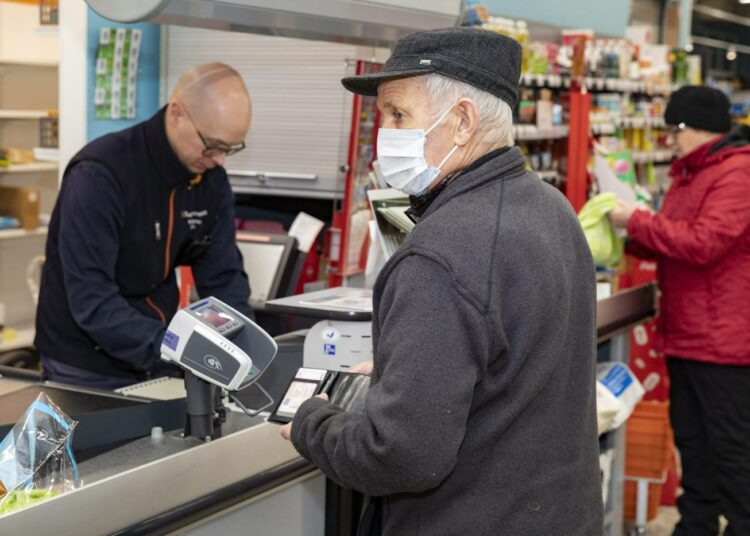 Kauppiaat Heli ja Ilpo Romppanen avasivat Äänekosken Suolahdessa K-Supermarket Suosikin aamukuudelta tiistaina riskiryhmille. Eero Hosio teki ostoksia kasvosuojuksella varustautuneena.