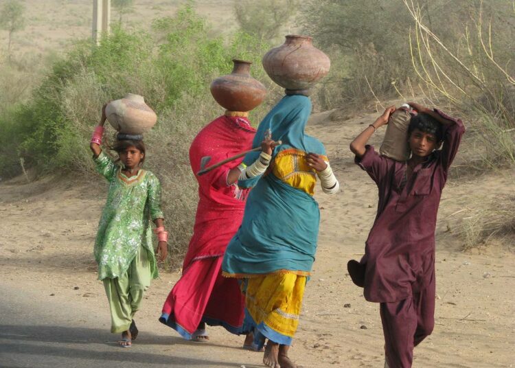 Peittävän pukeutumisen ei ole havaittu suojelevan naisia seksuaaliselta häirinnältä. Naisia vedenhakumatkalla Pakistanin Mithissä.