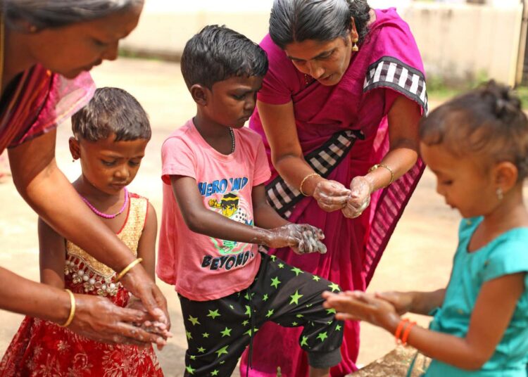 Lapsille opetetaan käsienpesua alkuperäiskansan asuinalueella Intiassa.