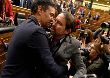 PSOE:n Pedro Sánchez ja Podemosin Pablo Iglesias syleilivät vasemmistohallituksen syntymisen varmistuttua Espanjan parlamentissa tiistaina.