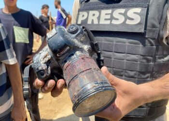 Toimittaja piteli Nasserin sairaalan iskussa surmatun kuvajournalisti Hussam al-Masrin veren peittämää kameraa tämän hautajaisissa.