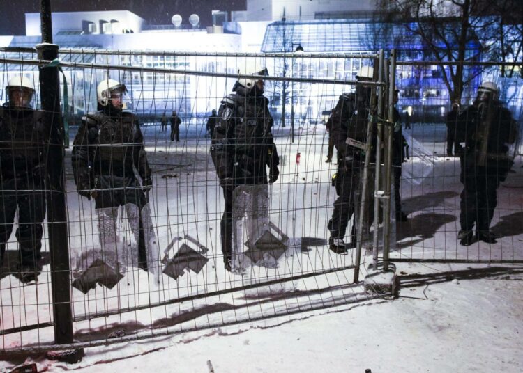 Poliisi valmiustilassa mellakka-aidan takana kiakkovieraiden mielenosoittajien varalta Tampere-talon edessä Tampereella 6. joulukuuta 2013.