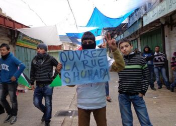Palestiinalaiset nuoret vaativat helmikuussa 2013 Shuhada-kadun avaamista. Katu oli aikoinaan vanhan Hebronin vilkkain markkinapaikka, mutta Israelin miehitysvalta sulki kaupat ja kielsi palestiinalaisia liikkumasta kadulla.
