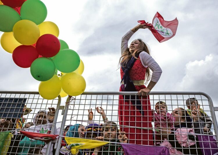 Kurdinainen heiluttaa opposition HDP-puolueen lippua Turkin kurdialueella.