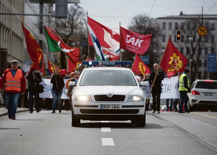 Kirjoittajien mukaan ammattiyhdistysliike on vaikeina aikoina työtätekevien turva. SAK:n liput liehuivat vappumarssilla Helsingissä viime keväänä.