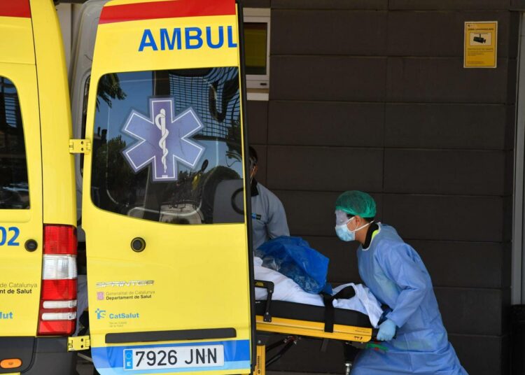 Komission tavoitteena on varmistaa ohjeillaan, ettei jo valmiiksi lujilla oleviin terveydenhuoltojärjestelmiin kohdistu yletöntä painetta. Sairaanhoitohenkilökunta siirtää potilasta ambulanssista Kataloniassa, Espanjassa.