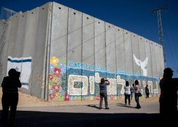Israelilaisturistit ottavat kuvia maansa Gazan-vastaisella rajalla sijaitsevasta muurista.