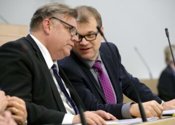 Ulkoministeri Timo Soini ja pääministeri Juha Sipilä kuiskailemassa toisilleen eduskunnan kyselytunnilla marraskuussa 2015.