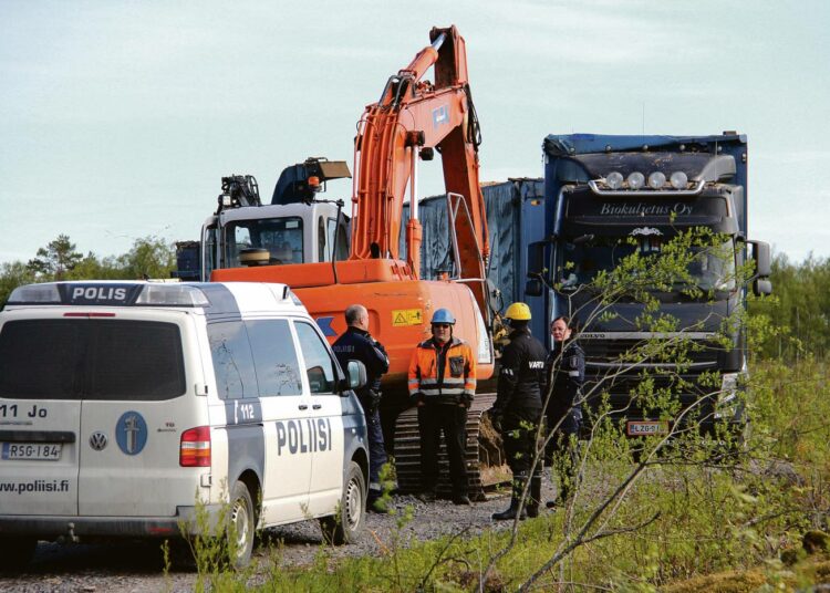 Poliisit ja kaivinkoneen kuljettaja keskustelivat töiden kulusta.