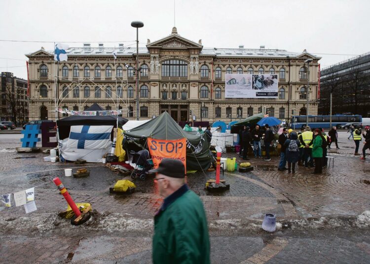 Tämä mielenosoitusleiri on Rautatientorin Ateneumin puoleisella laidalla. Toisella puolella, Aleksis Kiven patsaan edessä omaa leiriään pitää Suomi ensin -porukka. Välillä he käyvät kiertämässä turvapaikanhakijoita ja huutavat ”Go home!”