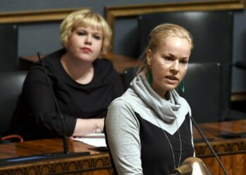 Vasemmistoliiton kansanedustaja Hanna Sarkkinen (edessä) ja perhe- ja peruspalveluministeri Annika Saarikko (taustallla) eduskunnan täysistunnossa maanantaina.