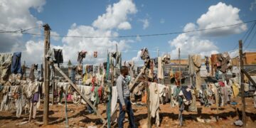 Mies katseli joukkohaudoista esiin kaivettujen kansanmurhan uhrien narulle ripustettuja vaatteita Ruandan pääkaupungin Kigalin laitamilla huhtikuussa.