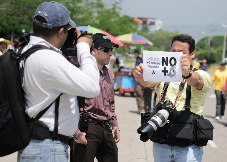 ”Jo riittää. Totuutta ei saa hengiltä tappamalla journalisteja”, hondurasilainen valokuvaaja julistaa.
