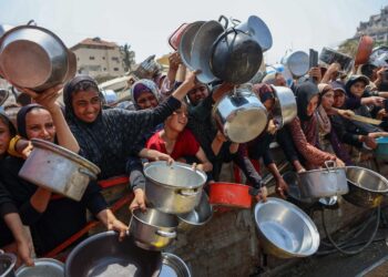 Nälän riuduttamat Gazan asukkaat jonottavat ruokaa avustuspisteellä.