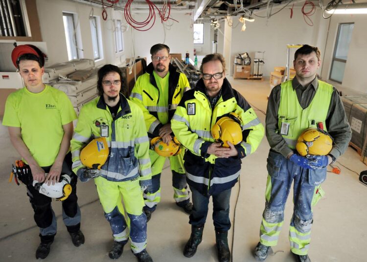NCC:n Plaza-työmaalla Vantaan Äyritiellä pysähtyivät työt hiljaisen hetken ajaksi. Kuvassa vasemmalta sähkömiehet Ville Leikas ja Jonatan Mishail, työsuojeluvaltuutettu Raino Kouvalainen, pääluottamusmies Teppo Rautiainen ja kittimies Denis Nikeshin.