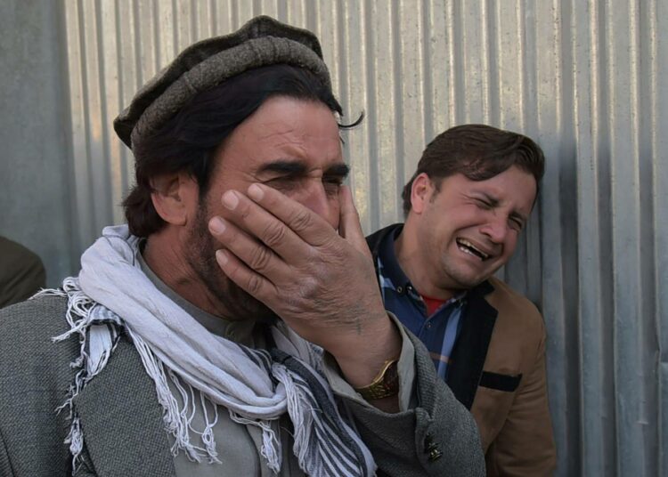 Afganistanilaismiehet surevat omaisiaan Kabulissa Isisin sotilassairaalaan tekemän hyökkäyksen jälkeen 8. maaliskuuta.