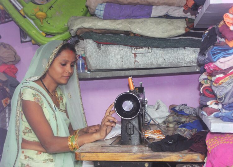 Nimaben Harishbai työskentelee ompelukoneellaan slummikotinsa pikkuruisessa ompelusopessa.