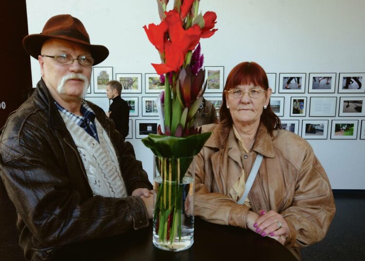 Kahdeksan vuoden asunnottomuuden kokeneet Meile Pentikäinen ja Sergei Sadejeff kuvasivat kodittomuutta Kiasman näyttelyyn. He poseeraavat Tarja Halosen lähettämän kukkakimpun kanssa.
