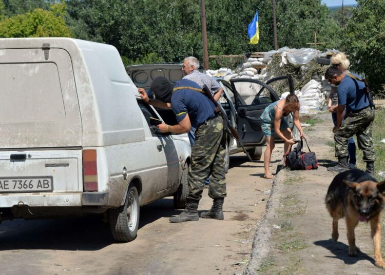 Ukrainan hallituksen puolella taistelevan vapaaehtoispataljoonan miehiä tarkastamassa maanantaina autoja kapinallisilta takaisin vallatun Lisitshanskin kaupungin laidalla.