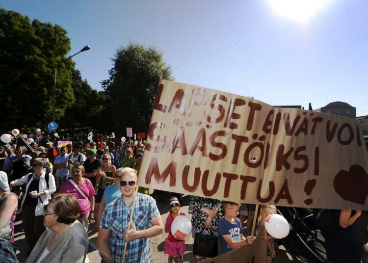Lapsia puolustava kyltti mielenosoituksessa hallituksen leikkauksia ja "kurjistamispolitiikkaa" vastaan Helsingissä 22. elokuuta.