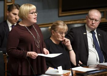 Perhe- ja peruspalveluministeri Annika Saarikko puhui  eduskunnan kyselytunnilla. Kuuntelemassa ministerikollegat Antti Häkkänen (takana), Pirkko Mattila sekä Jari Lindström.