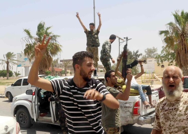 Libyan väliaikaishallituksen kannattajat juhlivat Libyan kansallisarmeijan joukkojen vetäytymistä Tarhunan kaupungista kesäkuussa.