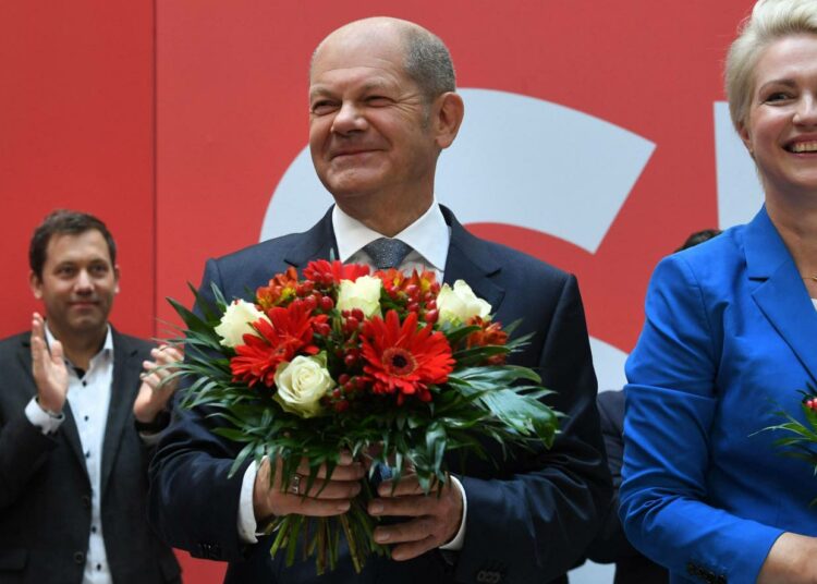 Saksan sosiaalidemokraattien kansleriehdokas Olaf Scholzilla (keskellä) oli syytä hymyyn sunnuntai-iltana.
