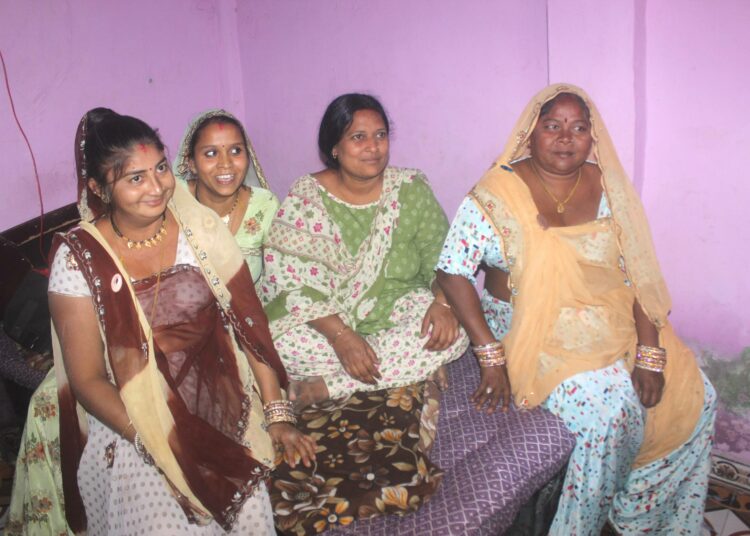 Mahila Housing Trustin kenttäorganisoija Niruben Badoria (toinen oikealta) vierailee säännöllisesti slummissa juttelemassa naisten kanssa.