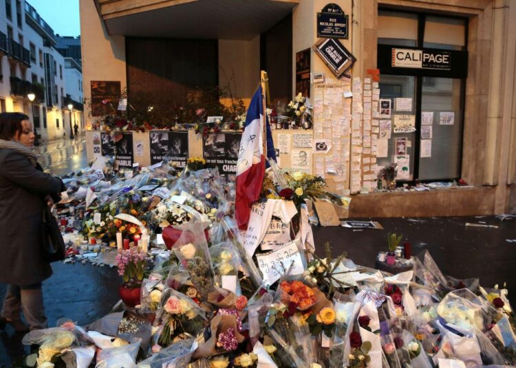 Katu Charlie Hebdon toimituksen edessä oli perjantaiaamuna täynnä kukkia. Keskiviikon verilöylyssä kuoli 12 ihmistä.