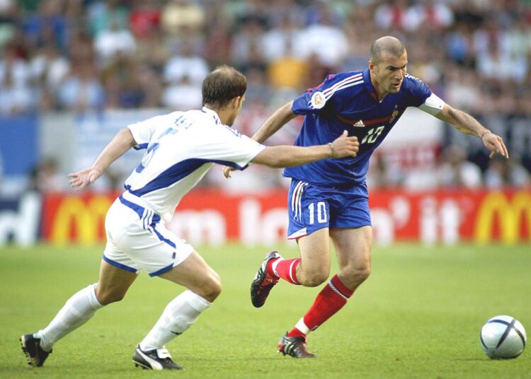 Kreikan Traianos Dellas (vas.) pelasi liberona Ranska-ottelussa vuoden 2004 EM-kisoissa. Oikealla Dellasia yrittää ohittaa Zinedine Zidane.