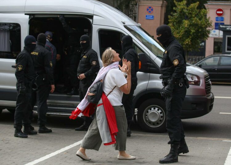 Nainen puhumassa mellakkapoliisille Minskissä tiistaina.