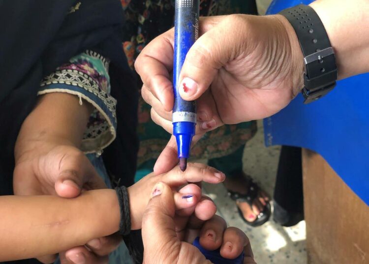 Rokottaja merkitsee lapsen sormen lähtemättömällä musteella rokotuksen saamisen merkiksi. Polionvastainen taistelu saavutti tärkeän merkkipaalun, kun Pakistanissa kului vuosi ilman yhtään uutta poliotapausta.