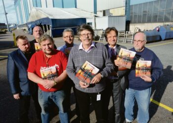 Hietalahden telakan ammattiosaston historiikin kirjoittaja vierellään joukko hänen haastattelemiaan pääluottamusmiehiä. Ilpo Haaja (vas.) , Veli-Matti Markkinen, Aulis Ukkola, Mikko Mielonen. kirjoittaja Timo Sandberg, Kari Uotila ja Erkki Ranta.