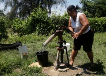 Nainen nostaa talousvettä käsipumpun avulla Martha Abreun perustuotantoyksikössä Keski-Cienfuegosin maakunnassa. Ilmastokriisin vuoksi lisääntyvät kuivat jaksot edellyttävät Kuubalta toimia vedensäästämiseksi ja uudelleenkäytöksi.