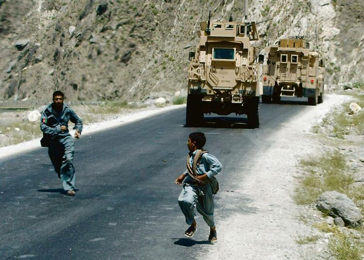 Afganistanin kiihtyvä väkivalta on nostattanut myös Puolassa keskustelua maan roolista kaukaisessa Keski-Aasiassa. Kuvassa afgaanipoliisi hätistelee pikkupoikaa pois amerikkalaisen sotilassaattueen läheisyydestä Peshin laaksossa Kunarin maakunnassa.