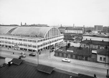 Kampin aluetta Fredrikinkadulta päin kuvattuna vuosina 1938-39. Tennispalatsia ympäröivät puurakennukset Kampintorilla ja taustalla ovat linja-autoasema, Maitokeskus ja Postitalo.