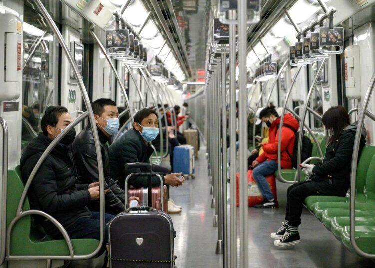 Kasvosuojuksilla varustautuneita metromatkustajia Shanghaissa.