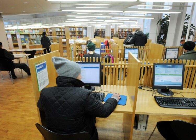 Monet ihmiset hoitavat asioitaan kirjaston tietokoneilla.