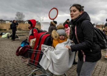 Kuvassa äiti ja lapsi pakenemassa sotaa Ukrainasta Puolaan.