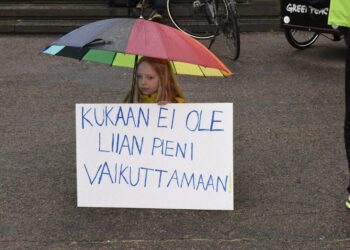 Lapsi Ilmastolakko-mielenosoituksessa hallitusneuvottelujen näyttämön Säätytalon ulkopuolella perjantaina.