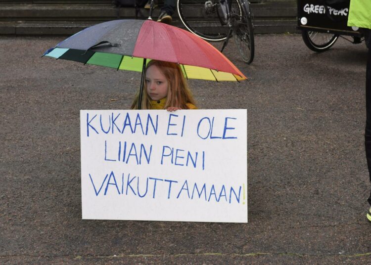 Lapsi Ilmastolakko-mielenosoituksessa hallitusneuvottelujen näyttämön Säätytalon ulkopuolella perjantaina.