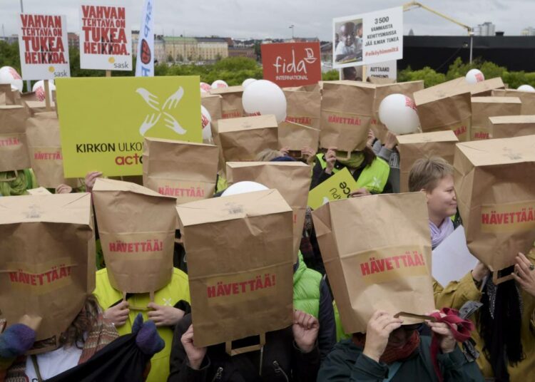 Mielenosoittajat vetivät paperipussit päähänsä, koska Suomen äkilliset leikkaukset kehitysyhteistyöstä hävettävät heitä.