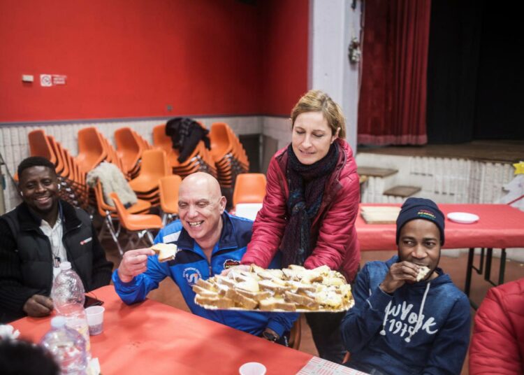 Africa Academyn joukkue tutustumassa paikallisiin asukkaisiin yhteisellä aterialla livornolaisessa monitoimitalossa.