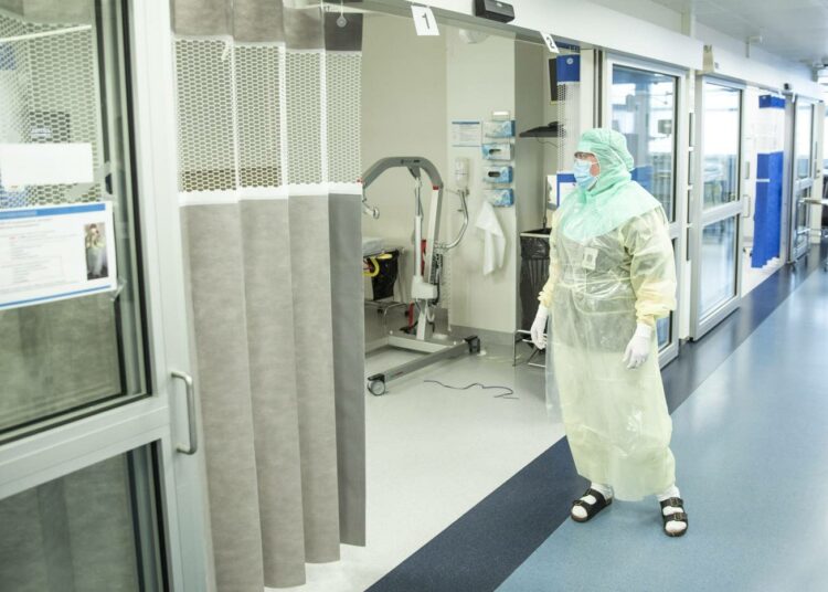 Hoitaja suojavarusteissa koronapotilaiden testaamiseen ja hoitoon tarkoitetulla osastolla Turun yliopistollisessa keskussairaalassa.
