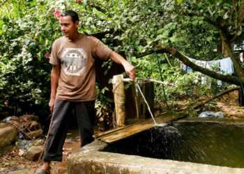Sitio el Zapotal -yhteisön jäsen täyttää vesiämpäriään kylän yhteisestä vesihanasta. El Salvadoriin on vuodesta 2010 lähtien rakennettu viisi pientä aurinkoenergialla toimivaa yhteisövesilaitosta, joista hyötyy nykyään noin 10 000 ihmistä
