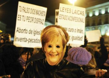 Etelä-Euroopassa euroa ei juhlita. Espanjassa työttömyys on noussut lähelle 23 prosenttia. Mielenosoittaja Madridissa naamioitui Saksan liittokansleri Angela Merkeliksi.
