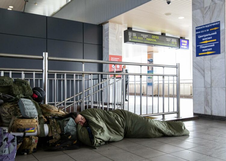 Vierastaistelija nukkuu Kiovan rautatieasemalla 26. maaliskuuta odottaessaan junan lähtöä Harkovaan.