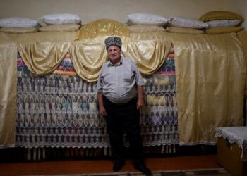 Armenian jesidien hengellisiin johtajiin lukeutuva Jundi Jundoyan seisoo pyhäinjäännöksiä peittävien kankaiden edessä.