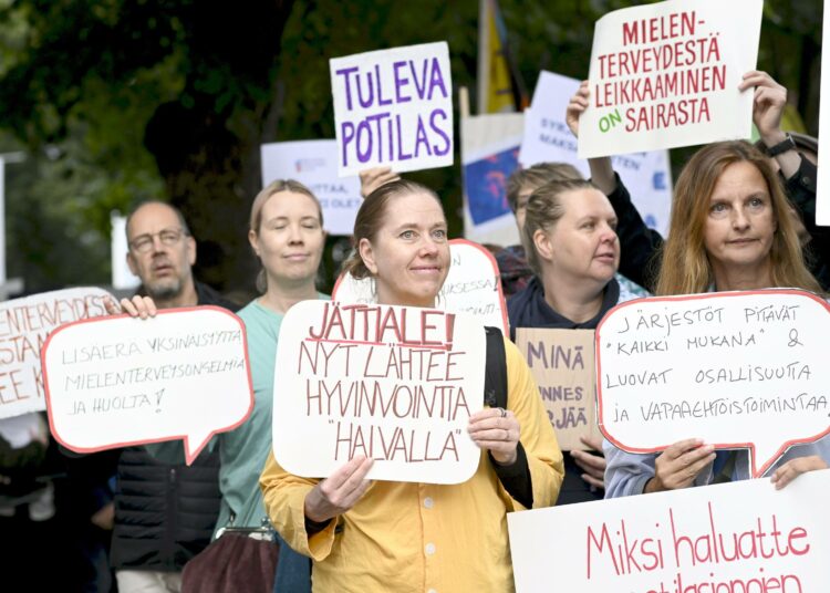 Mielenosoittajat tervehtivät budjettiriiheen saapunutta hallitusta.